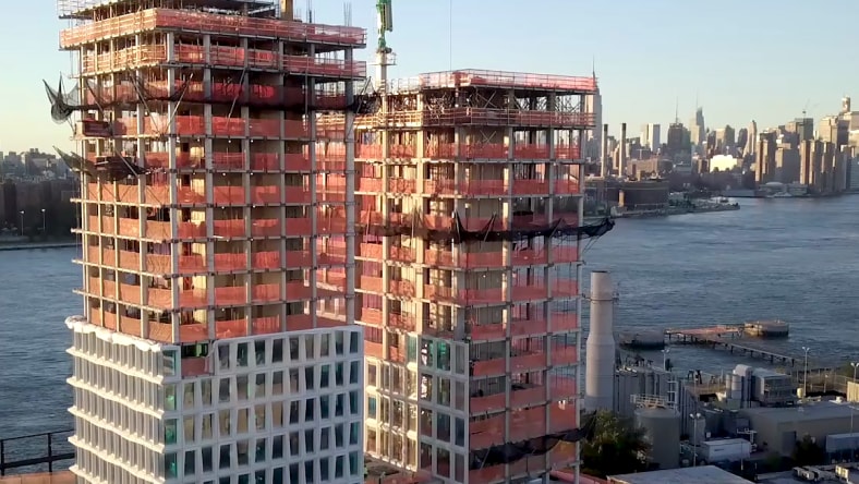 A building is being built beside a body of water