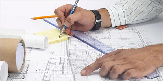 Close-up view of an architect working on blueprints.